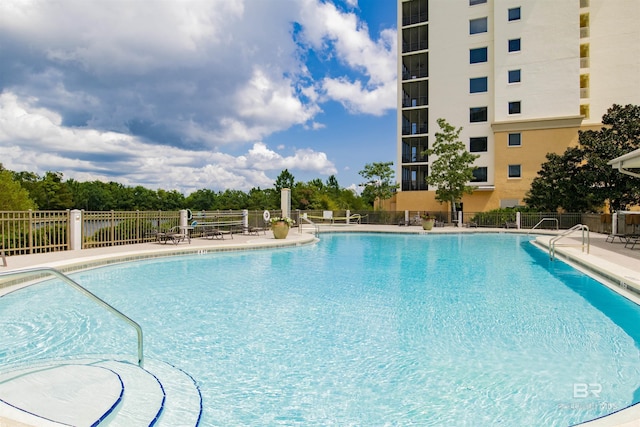 community pool featuring fence and a patio