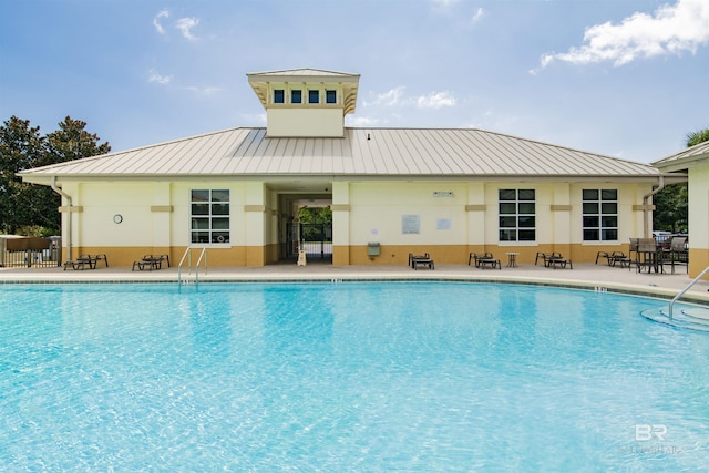 community pool with a patio area and fence