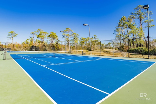 view of tennis court featuring fence