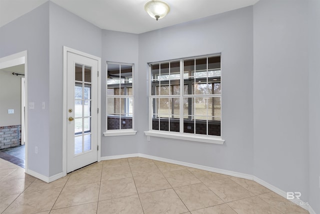 interior space with baseboards and tile patterned floors