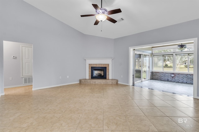 unfurnished living room with a ceiling fan, visible vents, a fireplace, and light tile patterned flooring