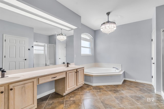 bathroom with double vanity, a shower stall, a chandelier, and a sink