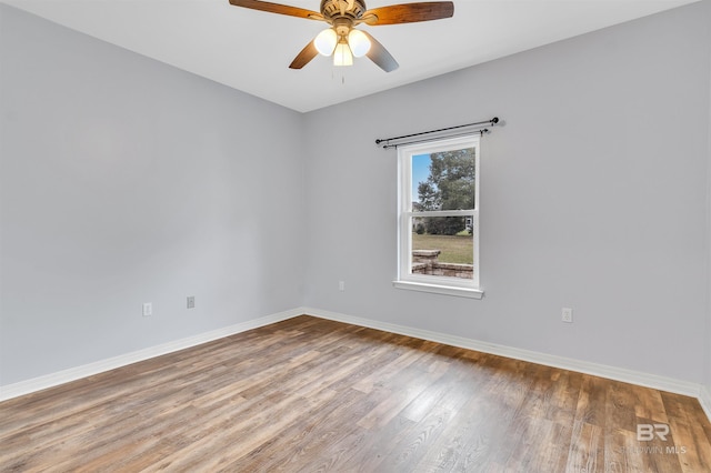 spare room featuring a ceiling fan, baseboards, and wood finished floors