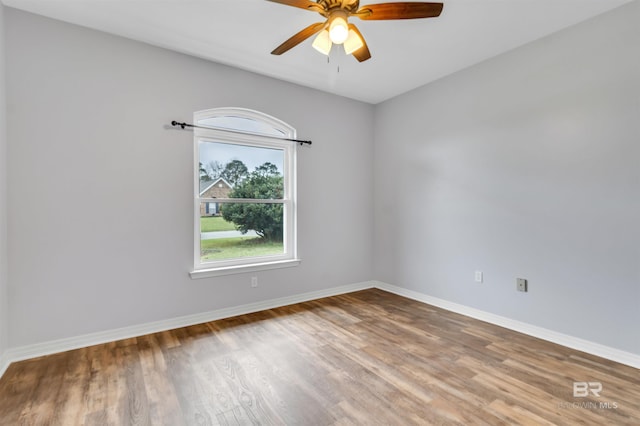 unfurnished room featuring wood finished floors, a ceiling fan, and baseboards