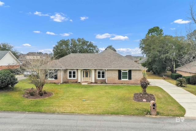 single story home with a shingled roof, brick siding, driveway, and a front lawn