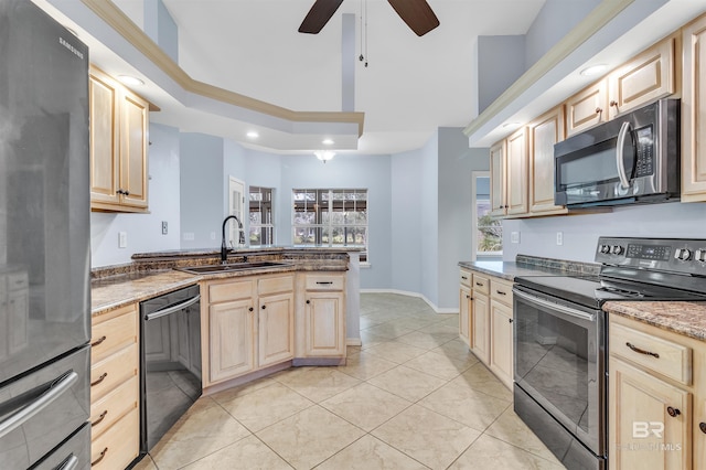 kitchen featuring light brown cabinetry, appliances with stainless steel finishes, and a sink