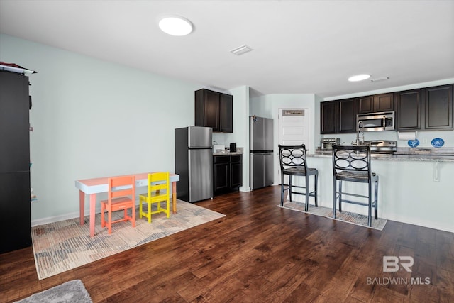 17372 Tallasee Blvd, Foley, AL 36535 - kitchen featuring appliances with stainless steel finishes, a kitchen breakfast bar, and dark wood-type flooring