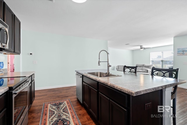 17372 Tallasee Blvd, Foley, AL 36535 - kitchen with appliances with stainless steel finishes, a kitchen breakfast bar, an island with sink, dark wood finished floors, and a ceiling fan