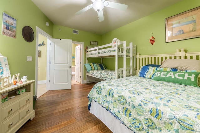 bedroom featuring hardwood / wood-style floors, ensuite bath, and ceiling fan