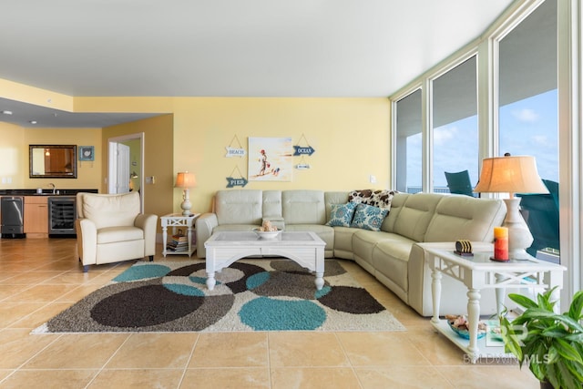 living room with floor to ceiling windows, wine cooler, sink, and light tile flooring