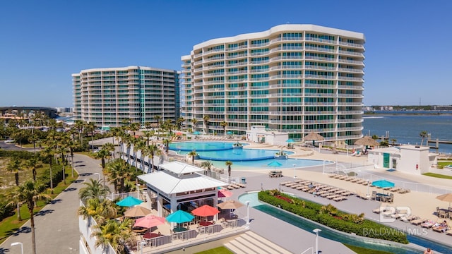 view of building exterior with a community pool and a water view