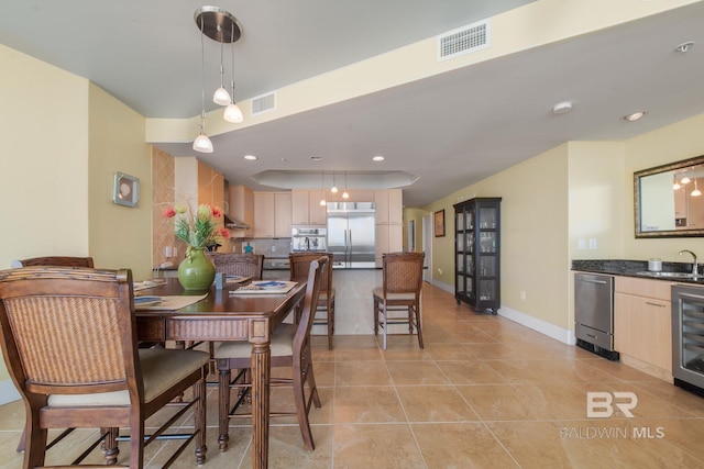 dining area with wine cooler, sink, and light tile floors