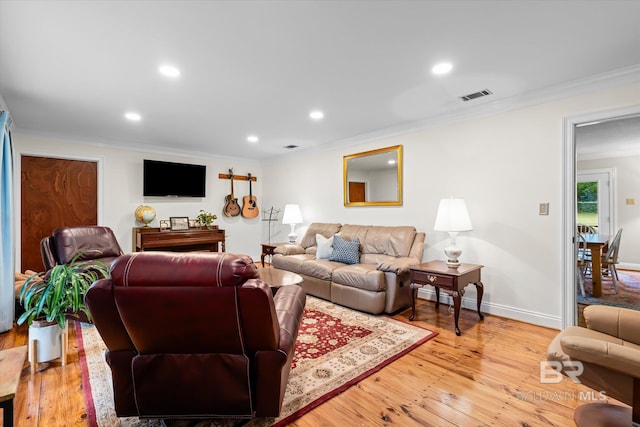 living room with ornamental molding and light hardwood / wood-style floors