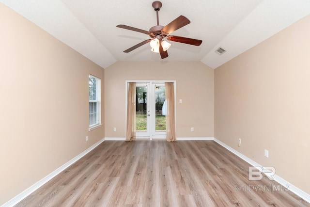 spare room with lofted ceiling, a textured ceiling, ceiling fan, and light wood-type flooring