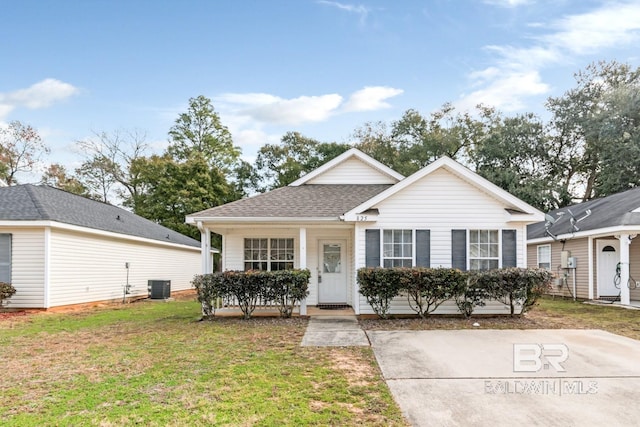 view of front of home with central AC unit and a front yard