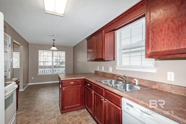 kitchen with sink, decorative light fixtures, a textured ceiling, kitchen peninsula, and white appliances