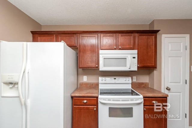 kitchen featuring a textured ceiling and white appliances