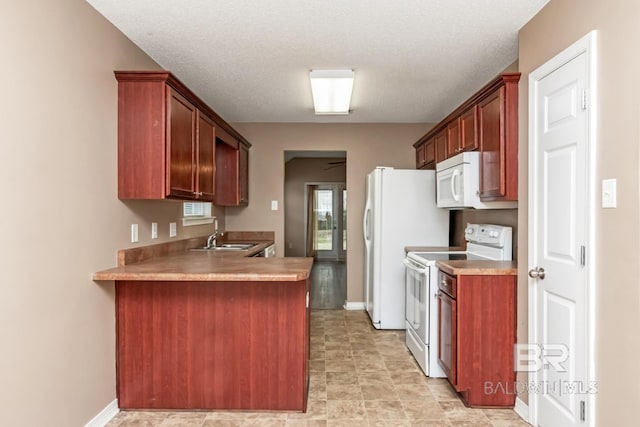 kitchen with white appliances, kitchen peninsula, sink, and a textured ceiling