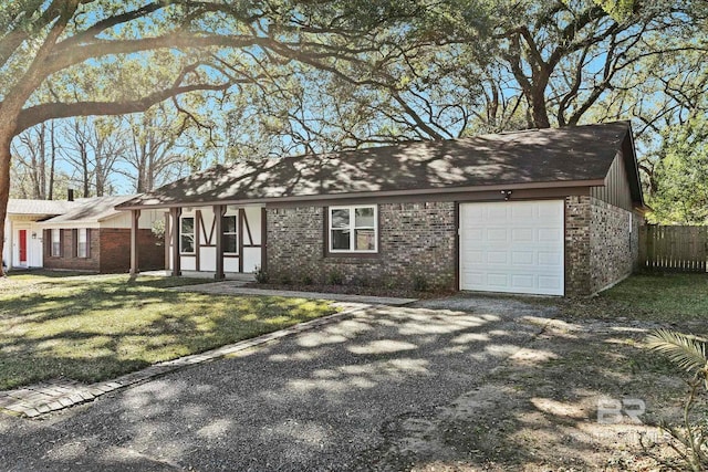 view of front of property featuring an attached garage, fence, a front lawn, and brick siding