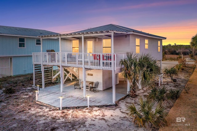 back house at dusk with a wooden deck