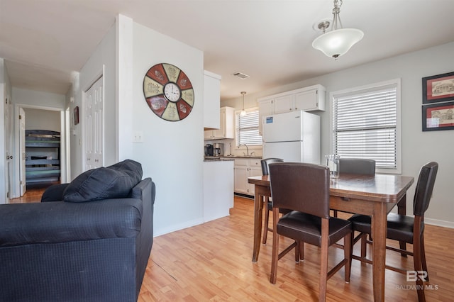 dining area featuring sink and light wood-type flooring