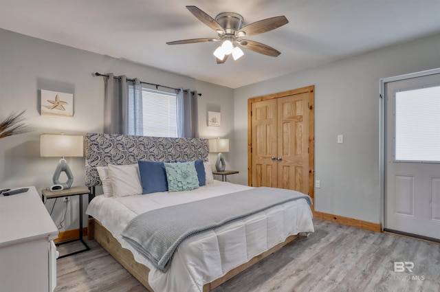 bedroom featuring ceiling fan, light hardwood / wood-style flooring, and a closet