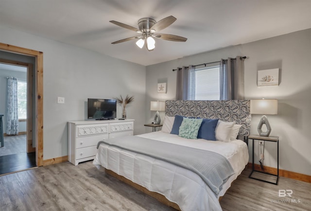 bedroom with multiple windows, ceiling fan, and light hardwood / wood-style flooring