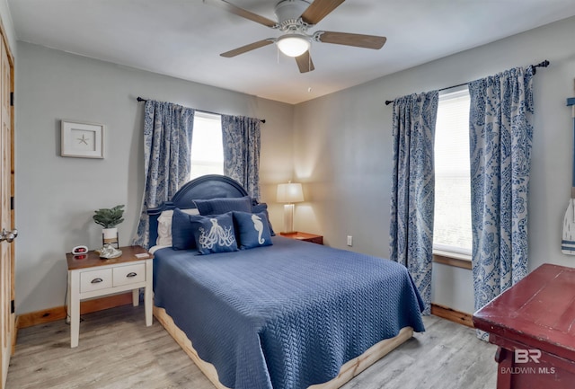 bedroom featuring multiple windows, light hardwood / wood-style floors, and ceiling fan