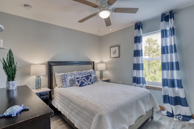 bedroom with hardwood / wood-style flooring, ceiling fan, and multiple windows