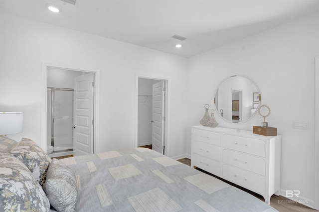 bedroom with a walk in closet, a closet, and wood-type flooring