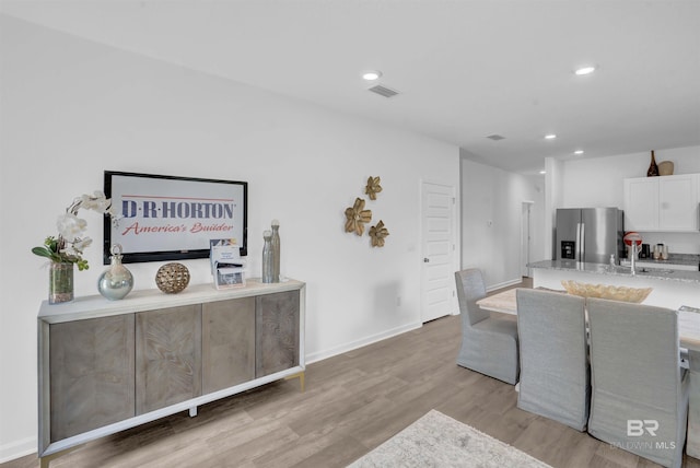 dining space featuring light wood-type flooring and sink