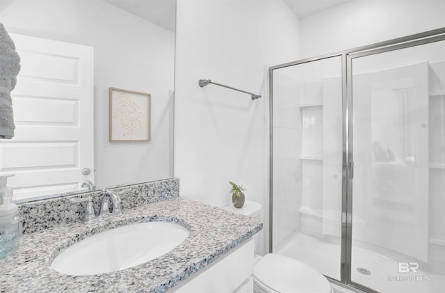 bathroom featuring vanity, toilet, and a shower with door