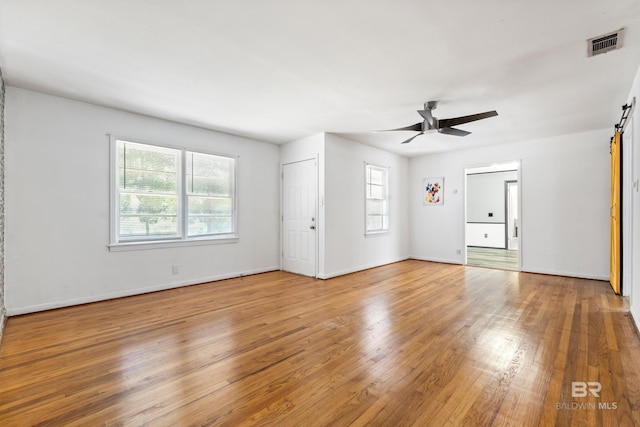 4014 Moffett Ct, Mobile, AL 36618 - unfurnished living room featuring a barn door, wood finished floors, ceiling fan, and baseboards