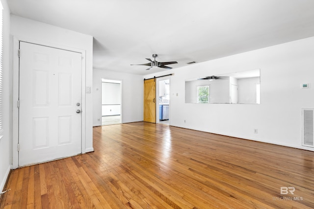 4014 Moffett Ct, Mobile, AL 36618 - unfurnished living room with ceiling fan, light wood-style flooring, a barn door, and baseboards