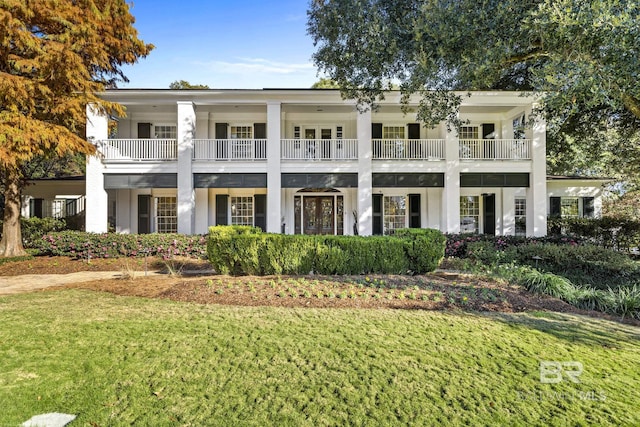 neoclassical home with a balcony and a front yard