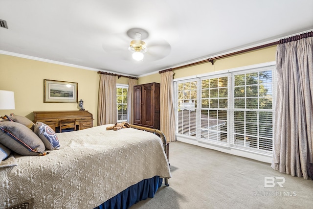 carpeted bedroom featuring ceiling fan, ornamental molding, and visible vents