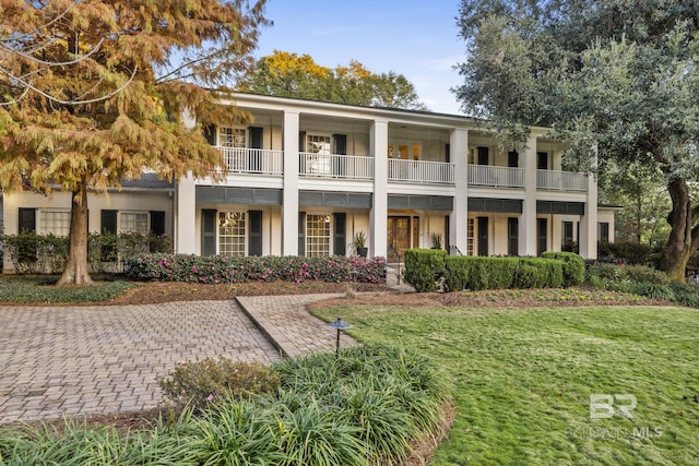 greek revival house with a front yard and a balcony