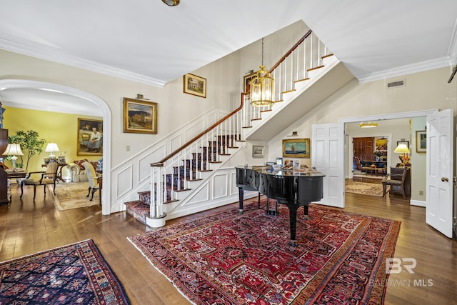 foyer featuring stairs, visible vents, dark wood finished floors, and crown molding