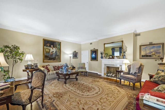 living room featuring ornamental molding, wood finished floors, and a fireplace with flush hearth