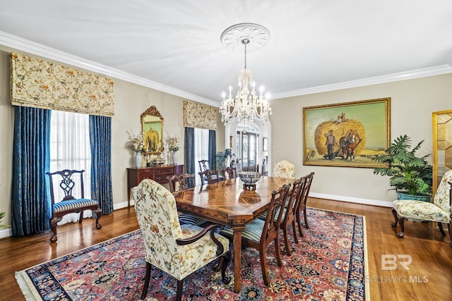 dining room with a healthy amount of sunlight, wood finished floors, and crown molding