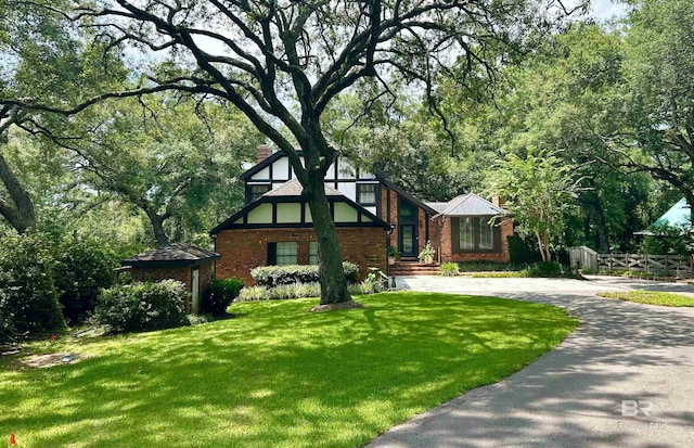 tudor house featuring a front lawn