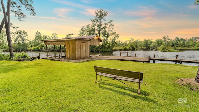 yard at dusk with a boat dock and a water view