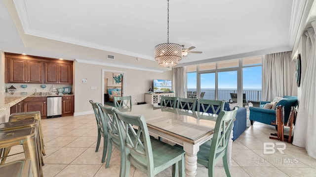 dining space featuring a chandelier, light tile patterned flooring, crown molding, and visible vents