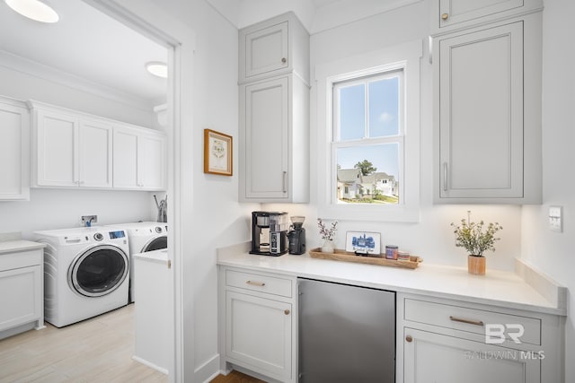 313 Cuban Lily Dr, Fairhope, AL 36532 - laundry room featuring independent washer and dryer, cabinet space, and light wood-type flooring