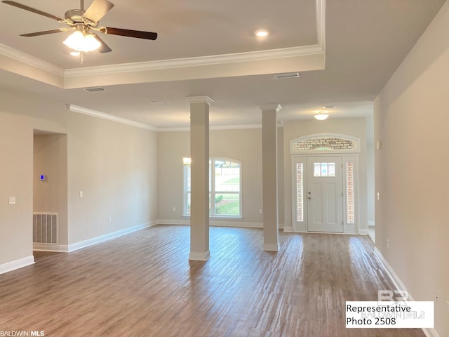 foyer with hardwood / wood-style flooring, ceiling fan, crown molding, and decorative columns