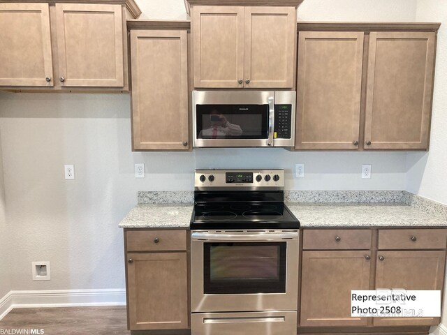 kitchen with appliances with stainless steel finishes, sink, and dark hardwood / wood-style floors