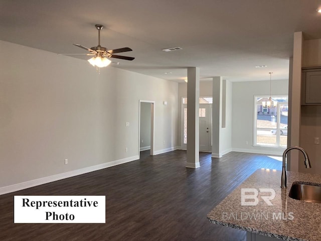 interior space featuring ceiling fan, sink, and dark wood-type flooring