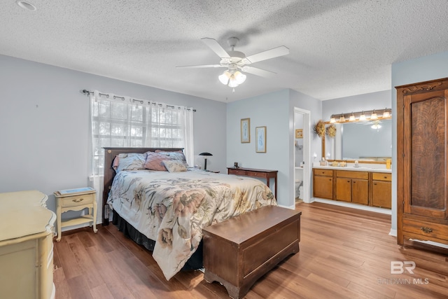 108 Paige Cir, Daphne, AL 36526 - bedroom featuring light wood finished floors, a textured ceiling, ensuite bath, and a ceiling fan