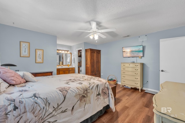 108 Paige Cir, Daphne, AL 36526 - bedroom featuring wood finished floors, a textured ceiling, connected bathroom, baseboards, and a ceiling fan