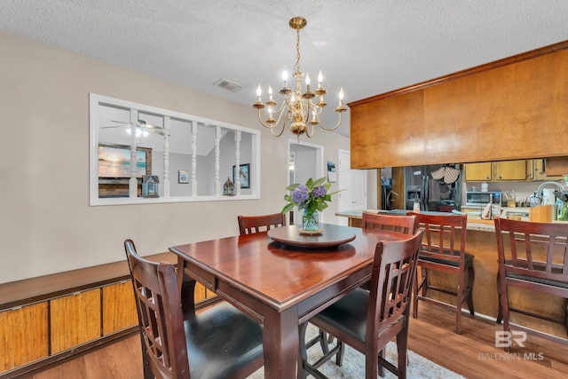 108 Paige Cir, Daphne, AL 36526 - dining space featuring wood finished floors, a textured ceiling, a chandelier, and ceiling fan